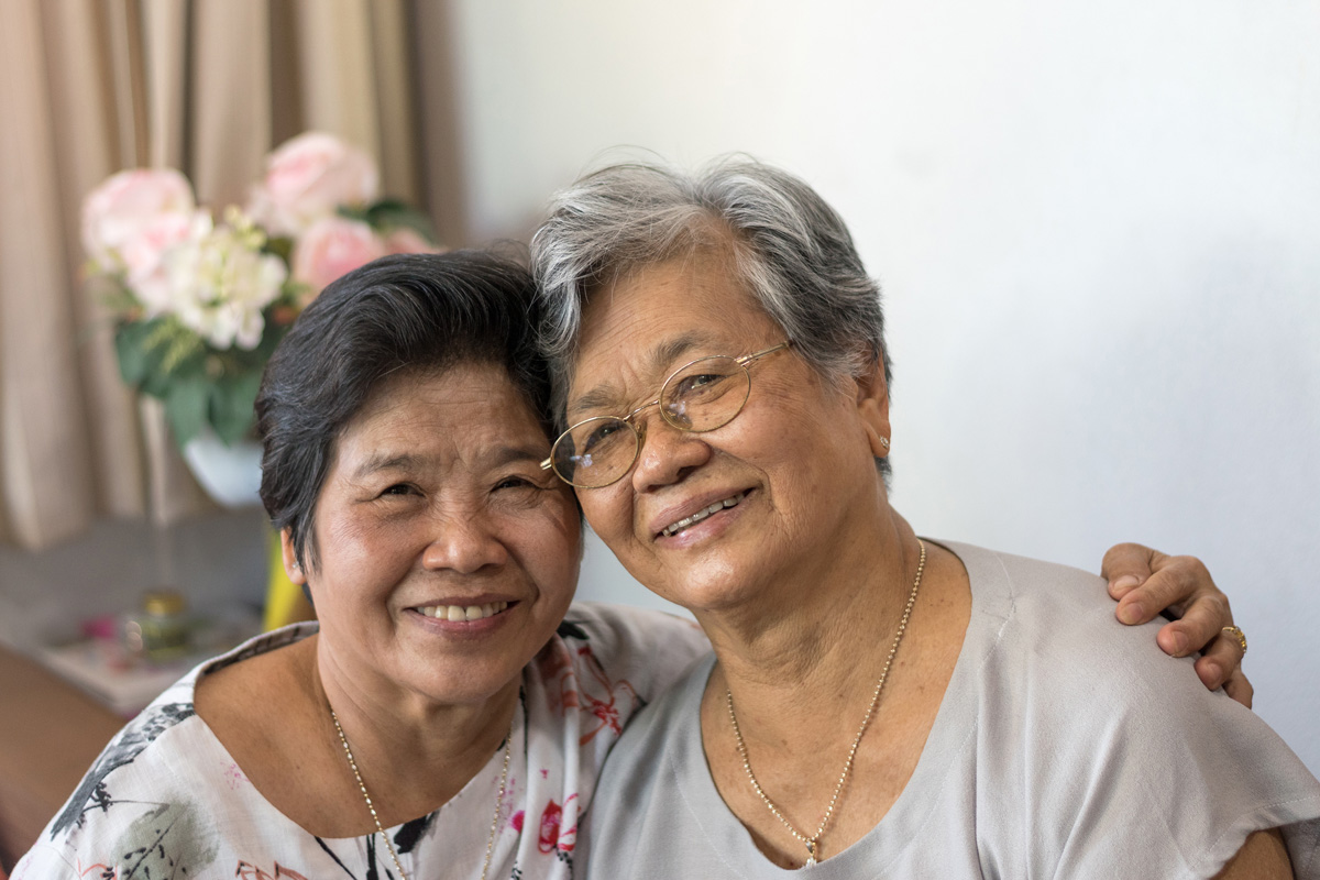 A senior woman smiles with her daughter.