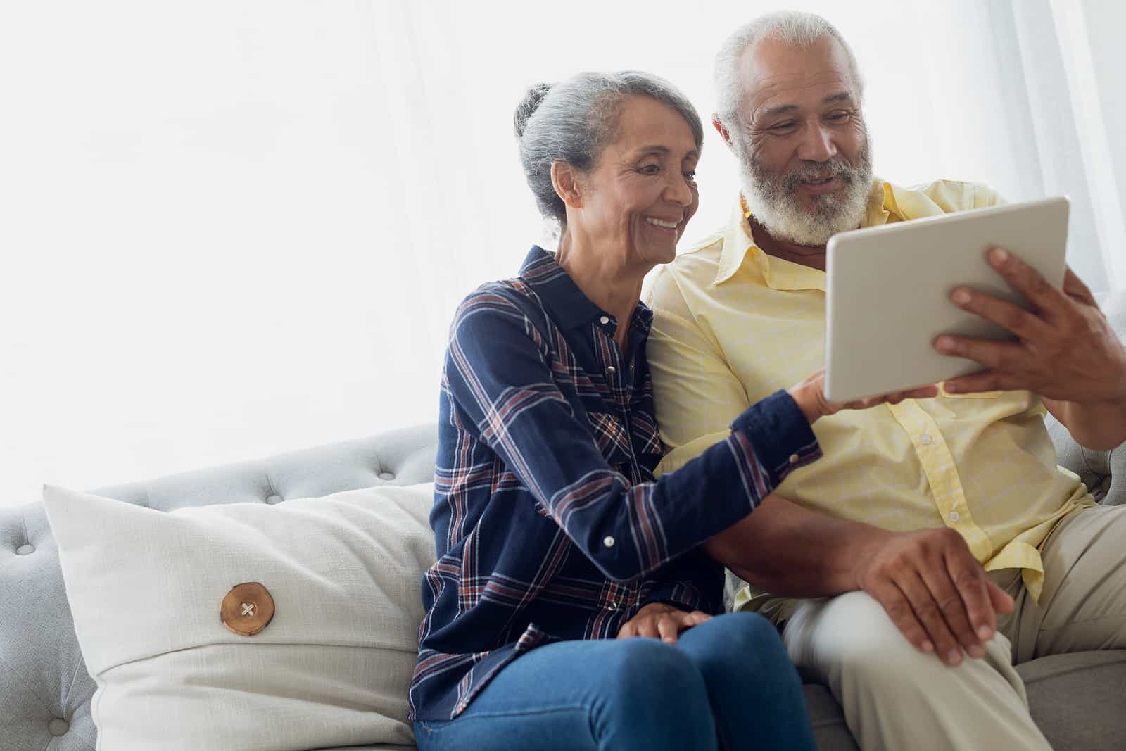 A senior couple look at a tablet together.