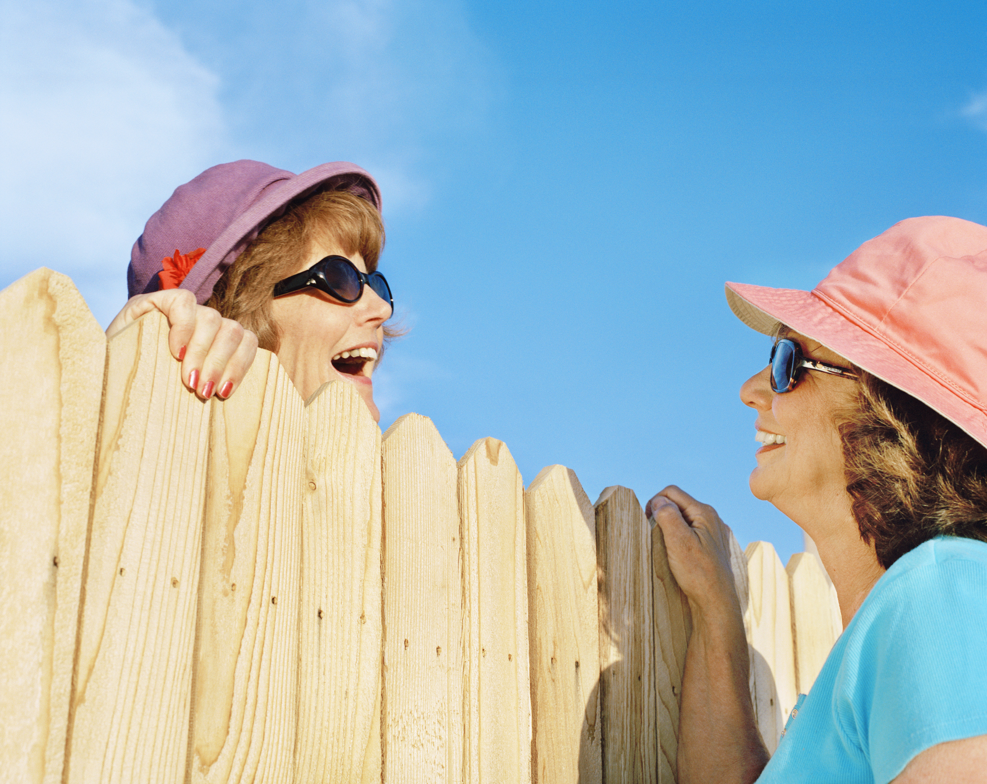 Mature women talking over fence