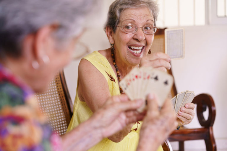 Two senior women playing a card game.
