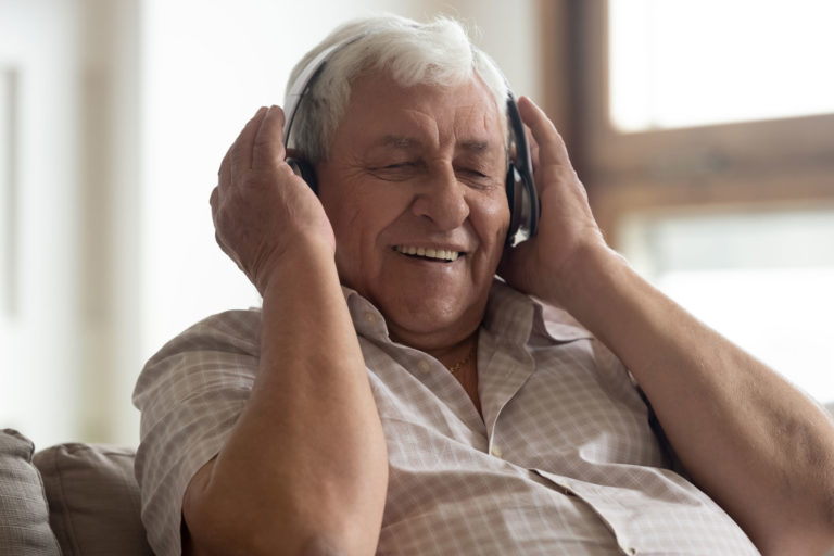A senior man listens to music in memory care.
